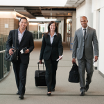 3 business people walking to go on a business trip